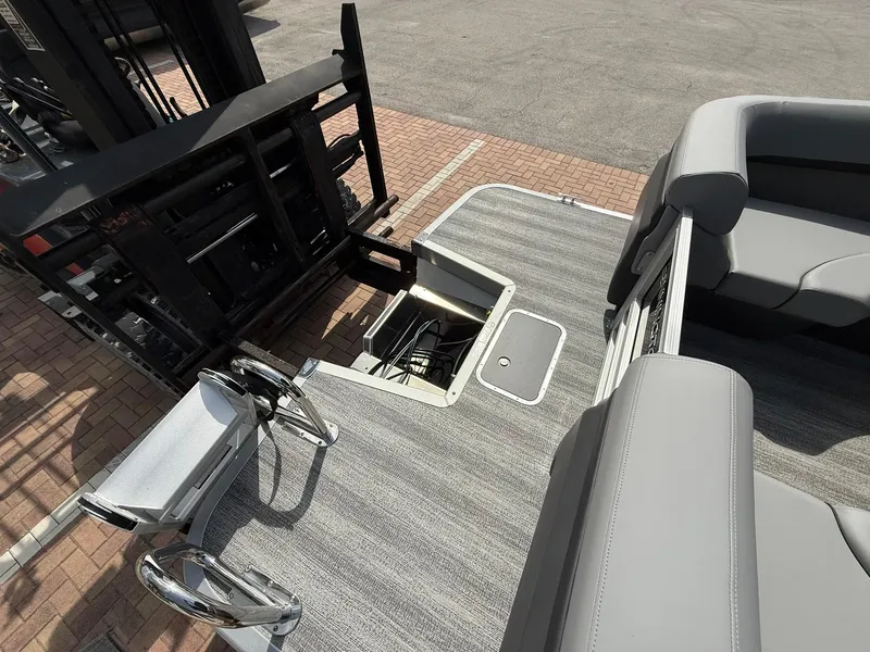 Slide: The Image of 2025 Bennington 22 MFB pontoon boat interior with open storage compartment and gray seating. - 3