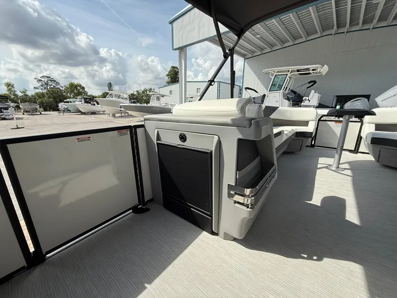 Slide: The Image of 2025 Bennington 26 MSB boat interior with seating and helm, under a sunny sky. - 15