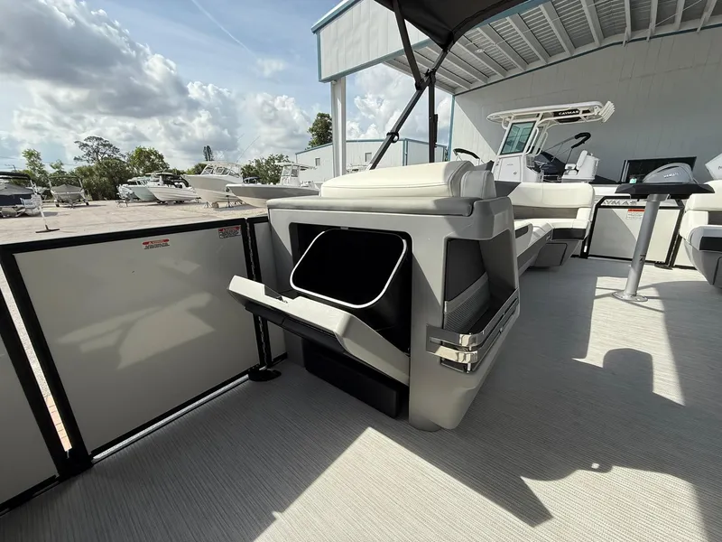 Slide: The Image of 2025 Bennington 26 MSB boat interior with seating and storage under a canopy. - 16