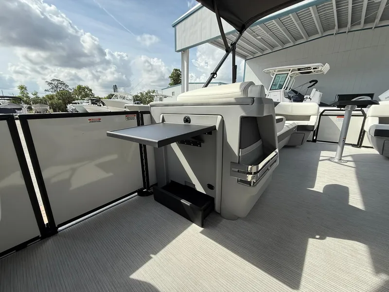 Slide: The Image of 2025 Bennington 26 MSB boat interior with seating and table under a canopy. - 17