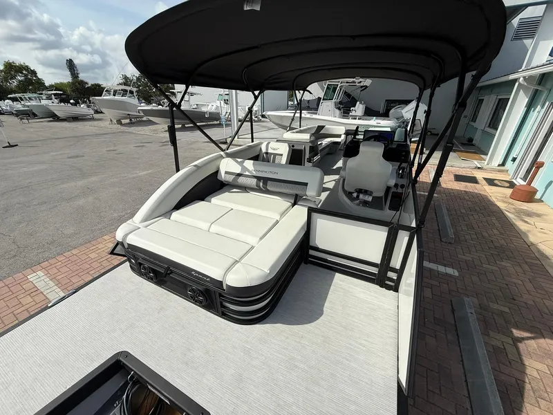 Slide: The Image of 2025 Bennington 26 MSB pontoon boat with spacious seating and canopy, docked at a marina. - 4