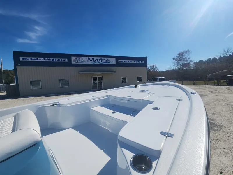 Slide: The Image of 2025 Blazer Bay 2200 boat at L&M Marine dealership under clear blue sky. - 10
