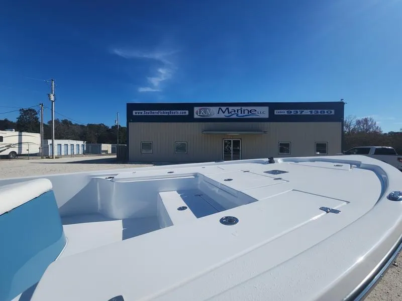 Slide: The Image of 2025 Blazer Bay 2200 boat at L&M Marine dealership under clear blue sky. - 16