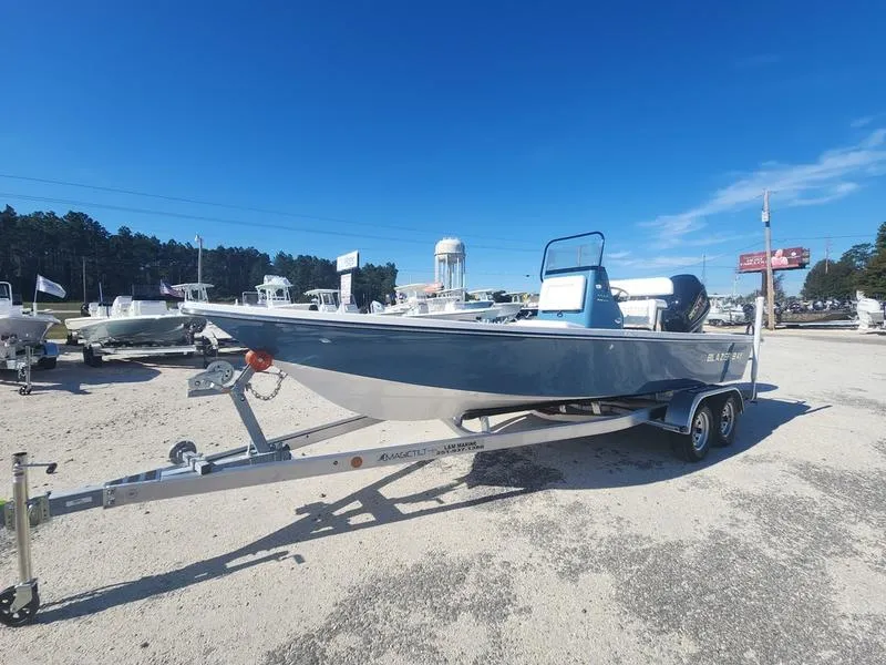 Slide: The Image of 2025 Blazer Bay 2200 boat on trailer under clear blue sky. - 4