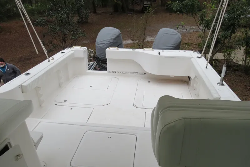 Slide: The Image of 2004 Baha Cruisers 290 King Kat boat deck with covered engines, surrounded by trees. - 12