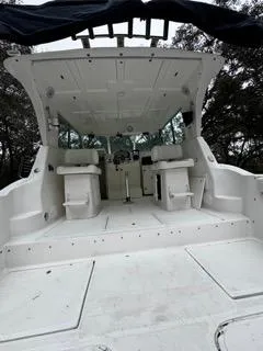 Slide: The Image of 2004 Baha Cruisers 290 King Kat boat interior with seating and helm, surrounded by trees. - 37