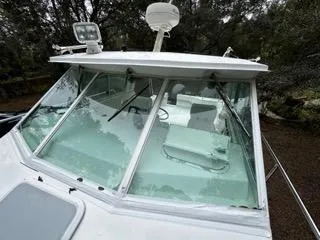 Slide: The Image of 2004 Baha Cruisers 290 King Kat boat with windshield and radar, surrounded by trees. - 42