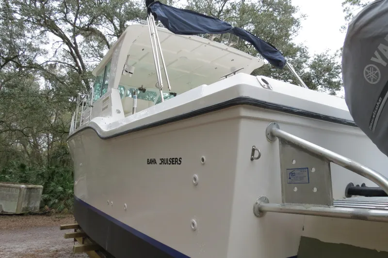 Slide: The Image of 2004 Baha Cruisers 290 King Kat boat with canopy, docked in wooded area. - 7