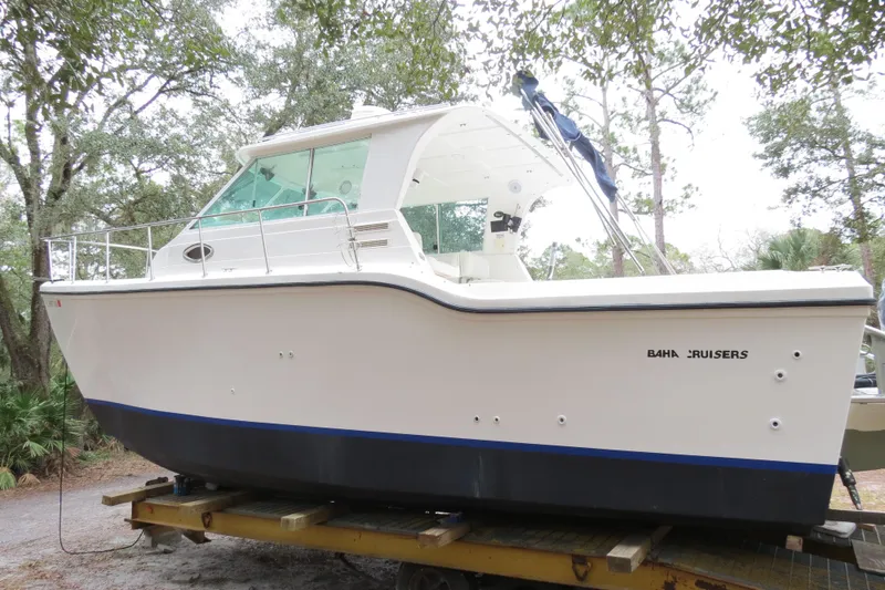 Slide: The Image of 2004 Baha Cruisers 290 King Kat boat on trailer, surrounded by trees. - 8