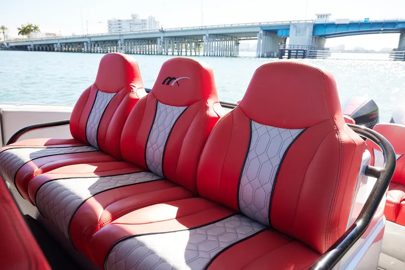 Slide: The Image of Red and gray seating on 2017 Midnight Express 43' Open boat, with bridge in background. - 12