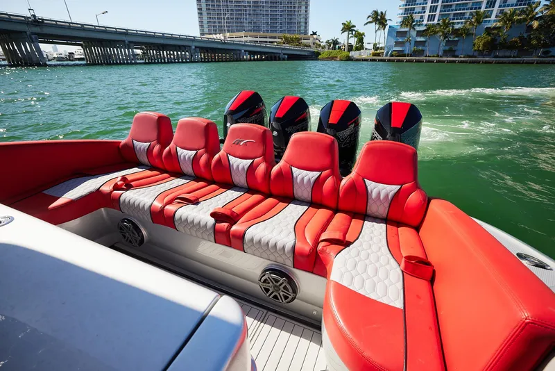 Slide: The Image of 2017 Midnight Express 43' Open boat with red and gray seating, cruising on a sunny day. - 16