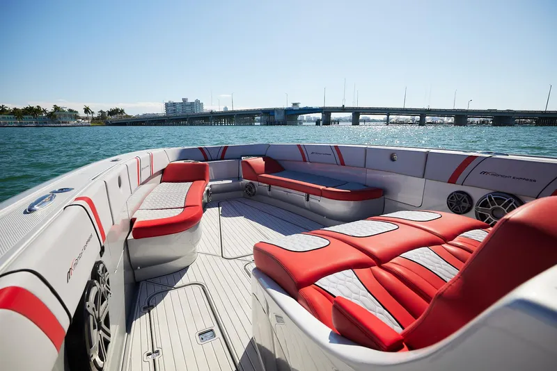 Slide: The Image of 2017 Midnight Express 43' Open boat with red and white seating, on calm water near a bridge. - 7