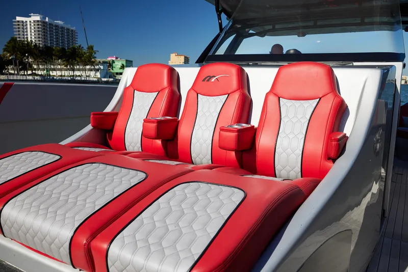 Slide: The Image of Red and white seating on 2017 Midnight Express 43' Open boat, docked with cityscape background. - 9