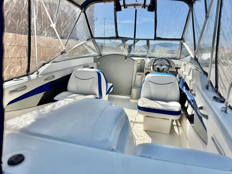 Slide: The Image of 2007 Bayliner 192 Cuddy Discovery interior with white seating and blue accents. - 11