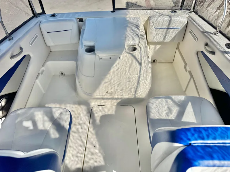 Slide: The Image of 2007 Bayliner 192 Cuddy Discovery boat interior with white seating and blue accents. - 13