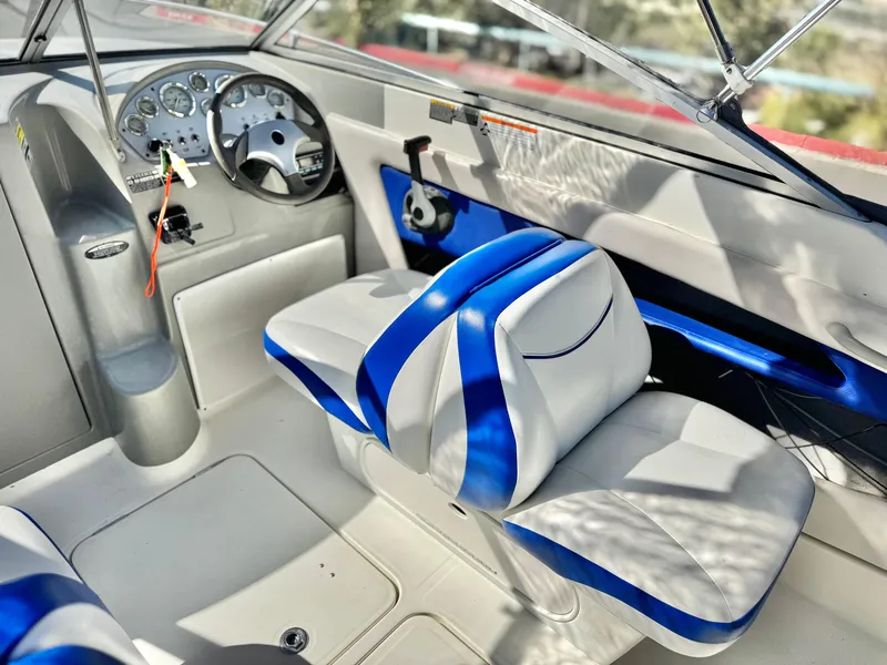 Slide: The Image of 2007 Bayliner 192 Cuddy Discovery boat interior with blue and white seating and dashboard. - 19