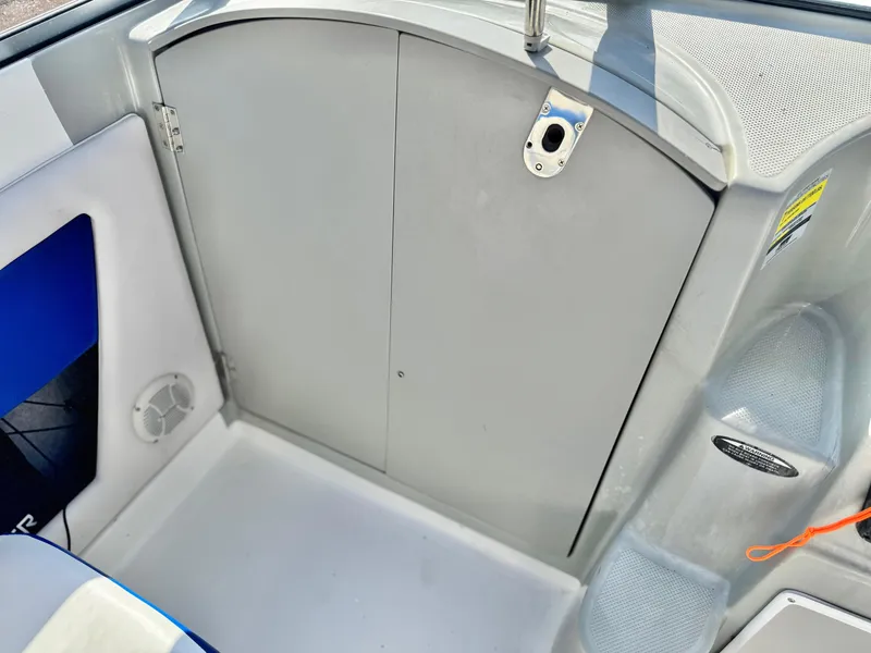 Slide: The Image of 2007 Bayliner 192 Cuddy Discovery interior, featuring a closed cabin door and seating area. - 22