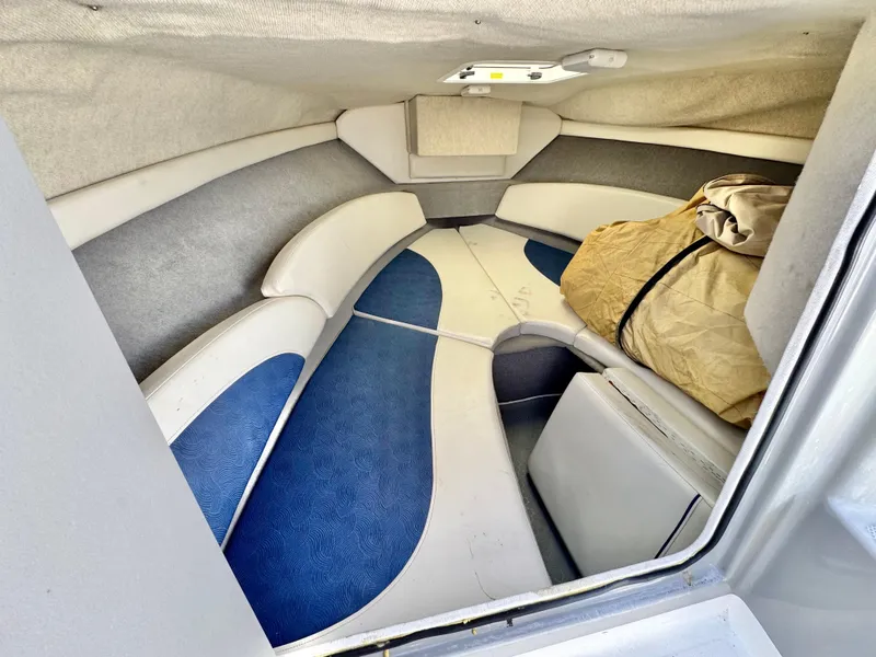 Slide: The Image of Interior of 2007 Bayliner 192 Cuddy Discovery boat, featuring cushioned seating and compact storage. - 24