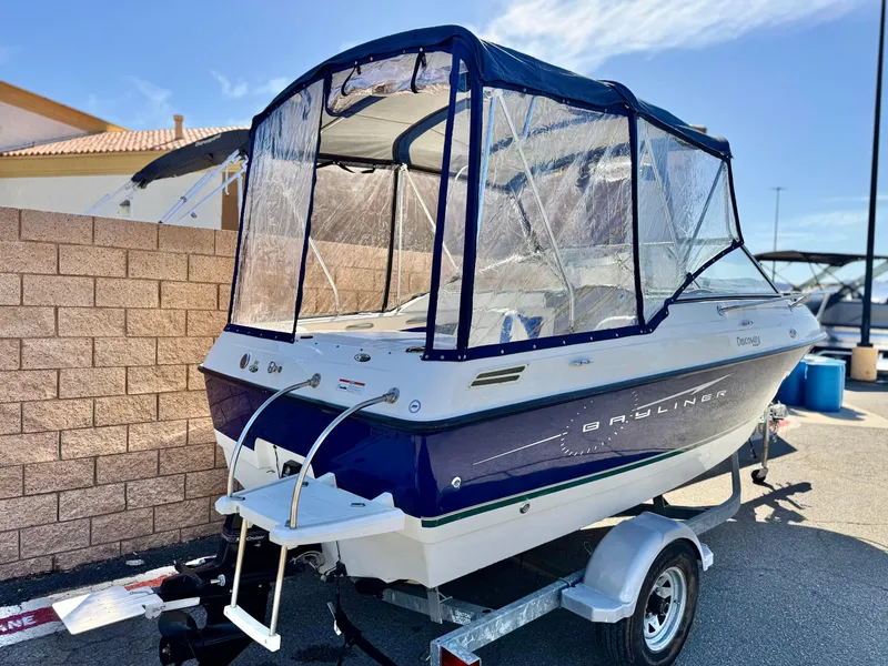 Slide: The Image of 2007 Bayliner 192 Cuddy Discovery boat on trailer, featuring blue and white design with canopy. - 5