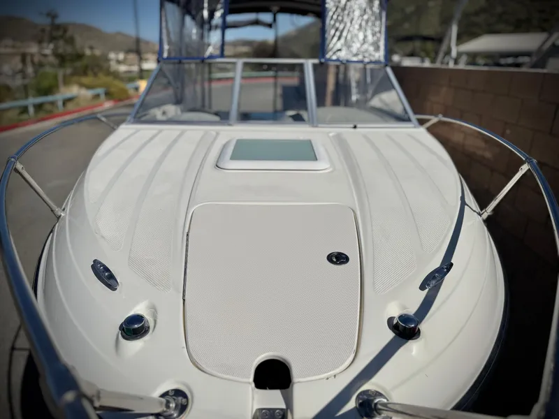 Slide: The Image of 2007 Bayliner 192 Cuddy Discovery boat, white exterior, docked with mountains in the background. - 7
