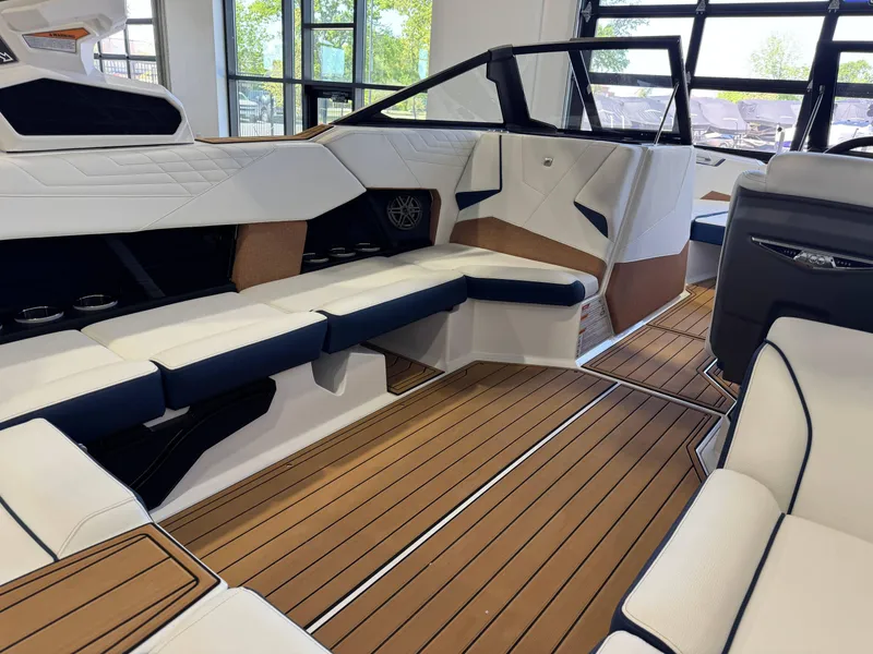 Slide: The Image of 2025 Nautique Super Air Nautique S23 interior with luxurious seating and teak flooring. - 13