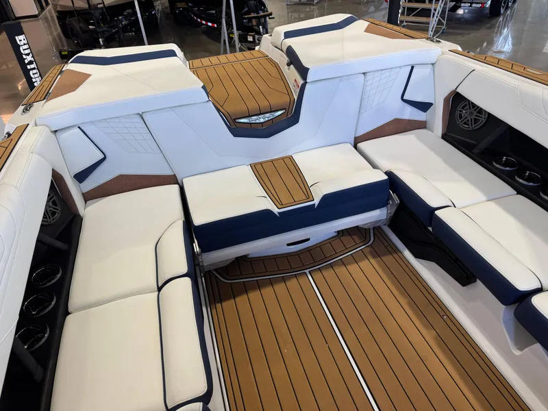 Slide: The Image of 2025 Nautique Super Air Nautique S23 interior with white and navy seating, teak flooring. - 15