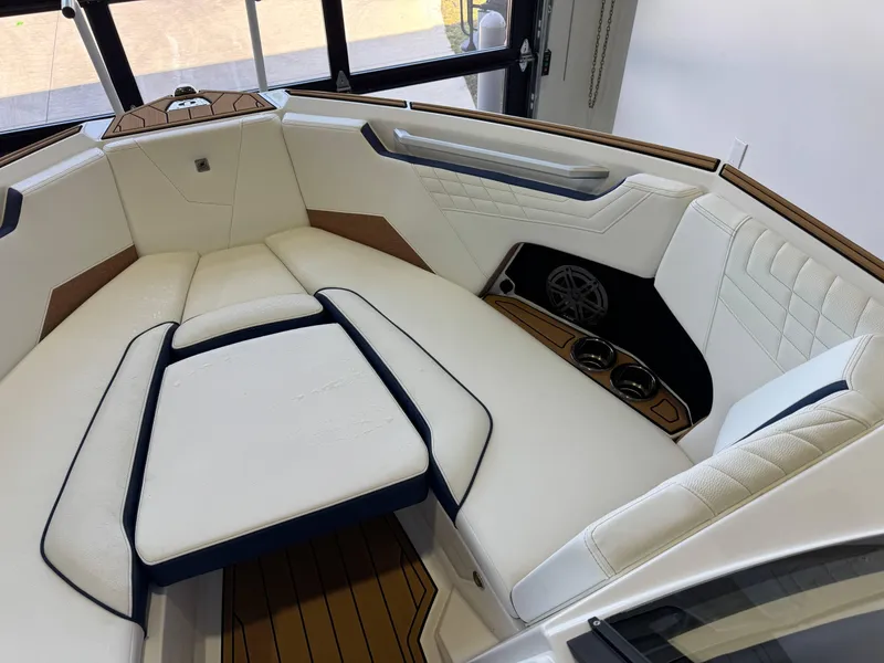 Slide: The Image of 2025 Nautique Super Air Nautique S23 interior with luxurious white seating and cup holders. - 17