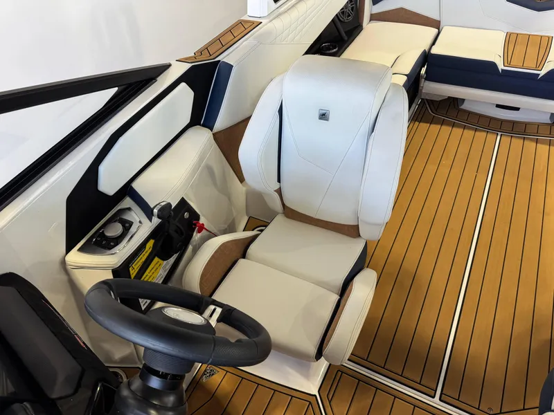 Slide: The Image of 2025 Nautique Super Air Nautique S23 interior with luxurious seating and modern steering wheel. - 20
