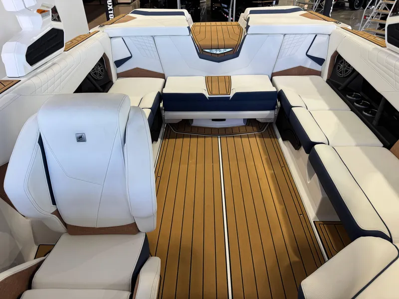 Slide: The Image of 2025 Nautique Super Air Nautique S23 interior with luxurious seating and teak flooring. - 21