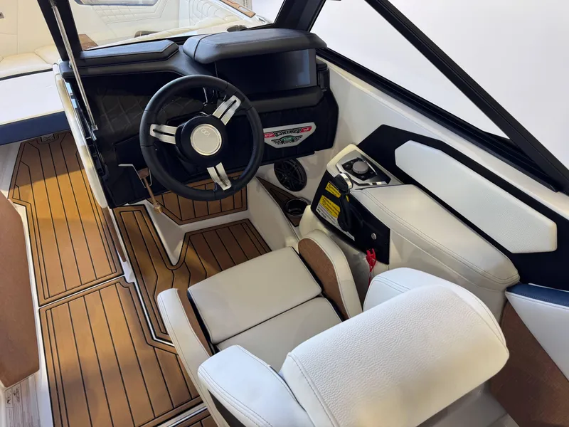 Slide: The Image of 2025 Nautique Super Air Nautique S23 boat interior with modern steering and seating. - 24
