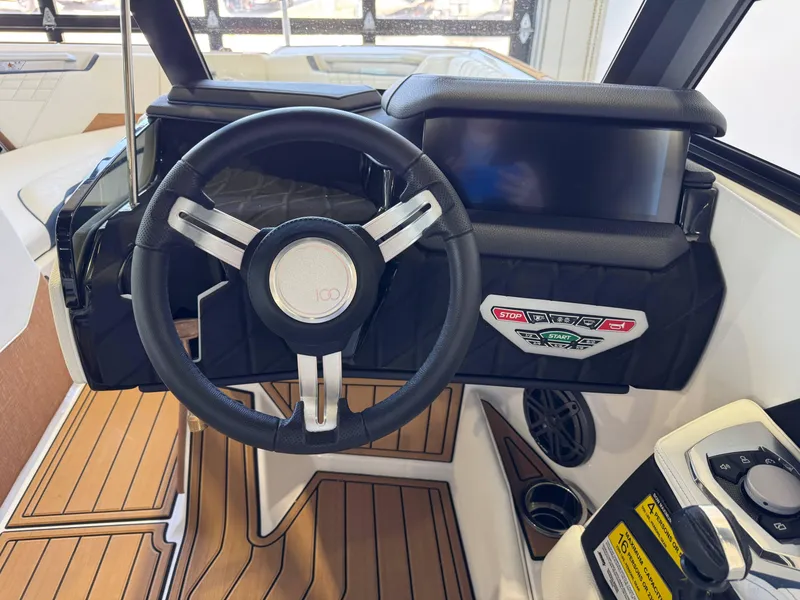 Slide: The Image of 2025 Nautique Super Air Nautique S23 dashboard with steering wheel and control panel. - 25