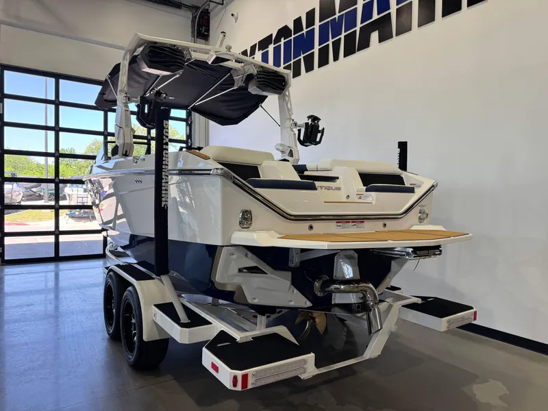 Slide: The Image of 2025 Nautique Super Air Nautique S23 boat in showroom, rear view with trailer. - 5