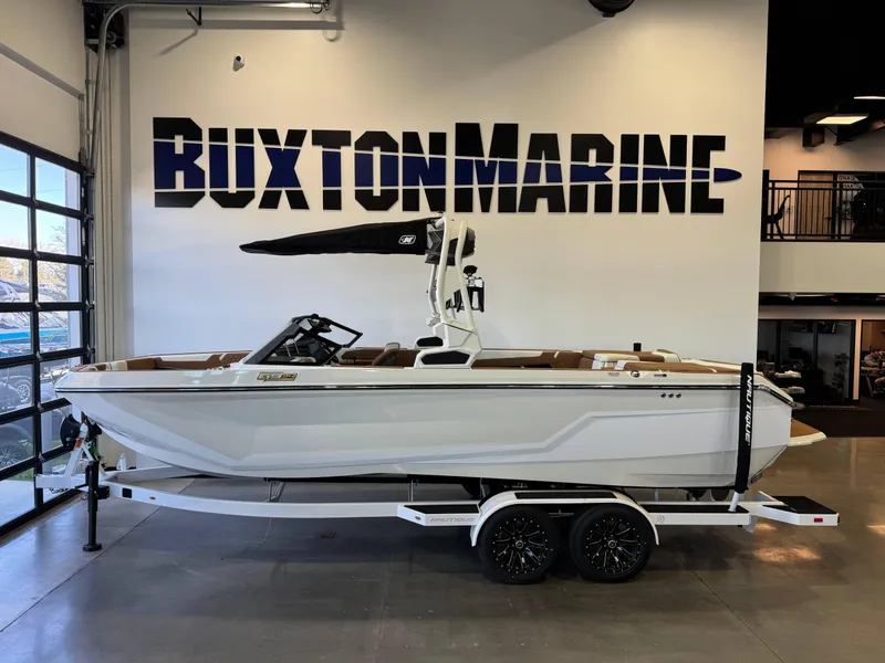 Slide: The Image of 2025 Nautique Super Air Nautique GS24 boat displayed at Buxton Marine showroom. - 1