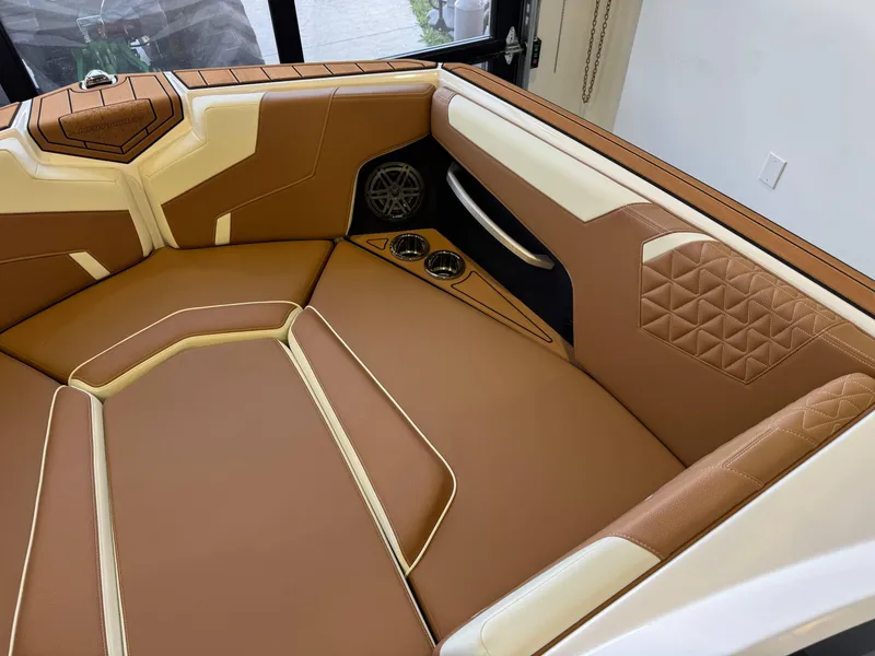Slide: The Image of 2025 Nautique Super Air Nautique GS24 interior with tan and white leather seating. - 18