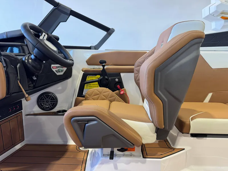 Slide: The Image of 2025 Nautique Super Air Nautique GS24 interior with tan seats and steering wheel. - 23