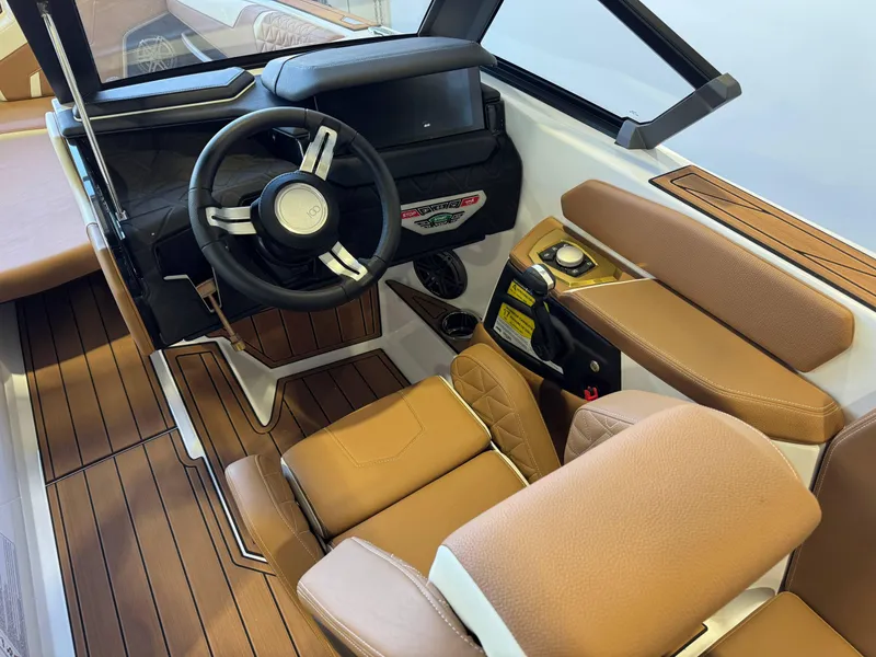Slide: The Image of 2025 Nautique Super Air Nautique GS24 cockpit with brown leather seats and modern steering wheel. - 25