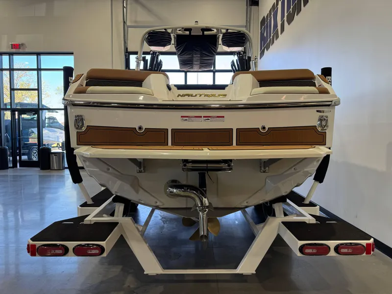 Slide: The Image of 2025 Nautique Super Air Nautique GS24 boat displayed indoors, rear view. - 6