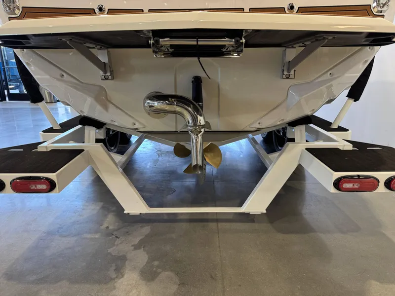 Slide: The Image of 2025 Nautique Super Air Nautique GS24 boat on trailer, rear view showing propeller and exhaust. - 7