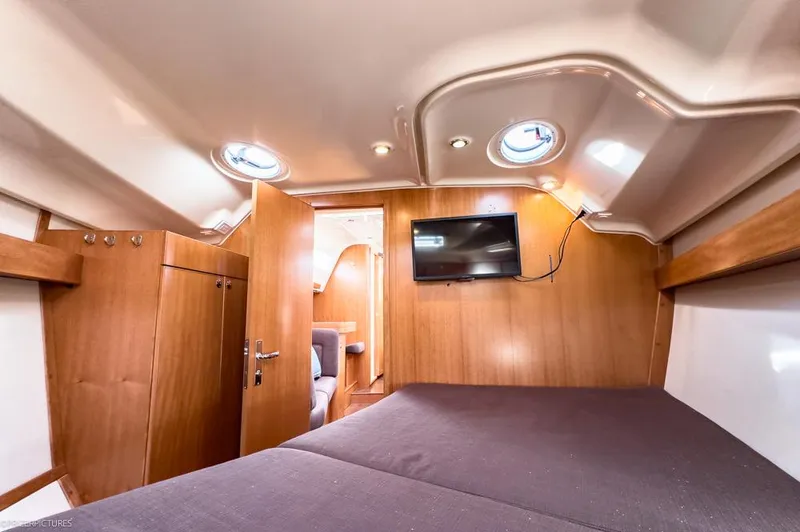 Slide: The Image of Interior of 2011 Elan Impression 384 yacht cabin with wood paneling and mounted TV. - 16