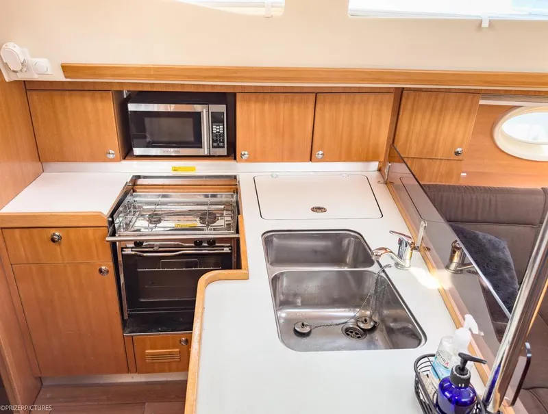 Slide: The Image of 2011 Elan Impression 384 yacht kitchen with stove, microwave, and double sink. - 18