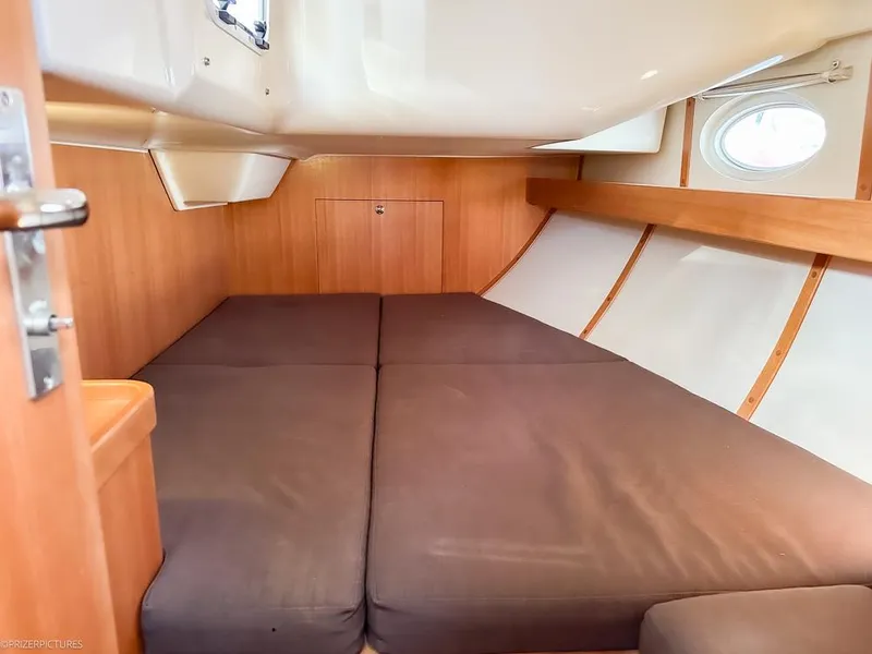 Slide: The Image of Cozy cabin interior of 2011 Elan Impression 384 sailboat with wooden finish and porthole. - 8