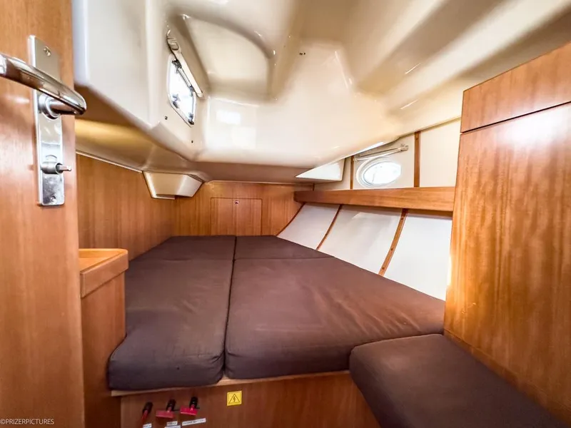 Slide: The Image of Cabin interior of 2011 Elan Impression 384 yacht with wooden finish and cozy bedding. - 9