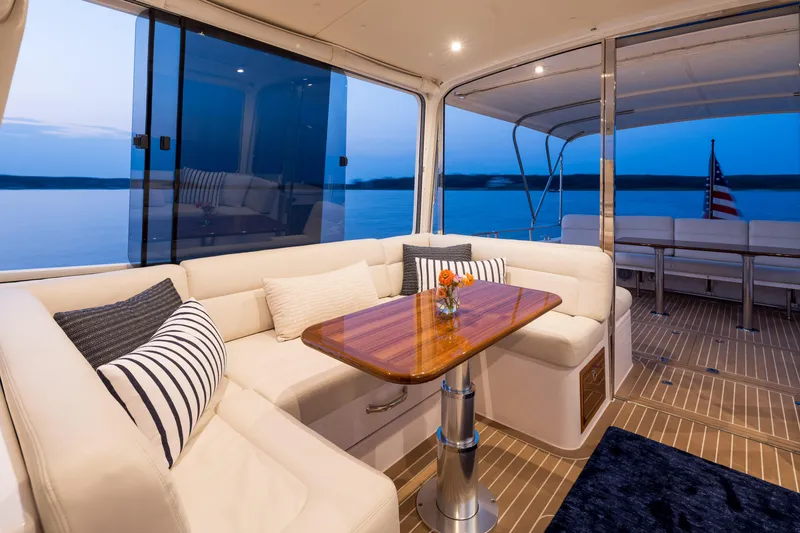 The Image of Luxurious 2020 MJM 53z yacht interior with elegant seating and wooden table at sunset. - 1