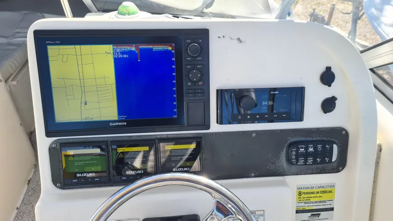 Slide: The Image of 2009 World Cat 250 DC dashboard with Garmin navigation and Suzuki controls. - 11