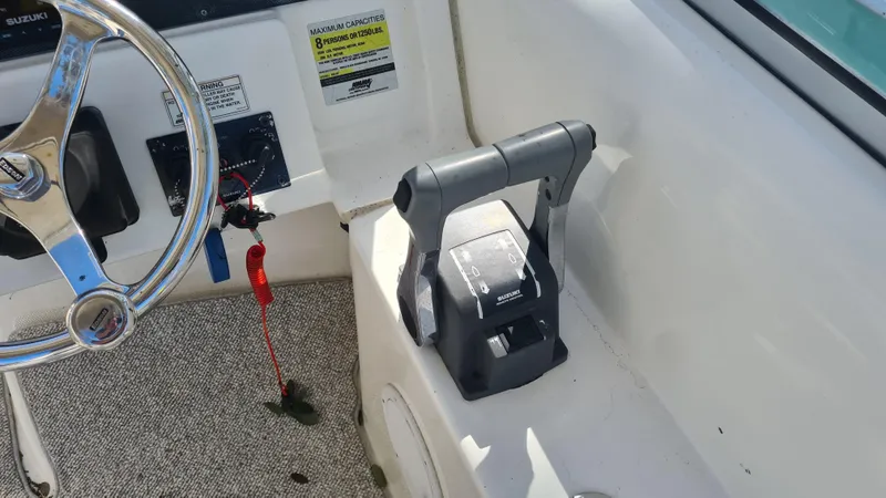 Slide: The Image of 2009 World Cat 250 DC boat cockpit with steering wheel and throttle controls. - 13