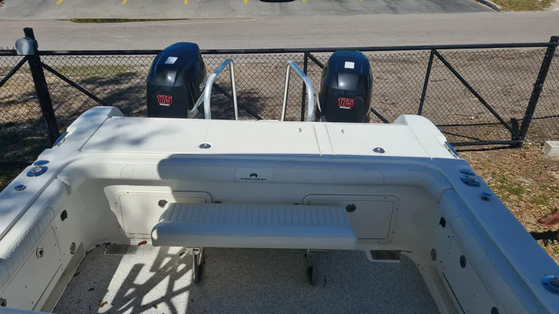 Slide: The Image of 2009 World Cat 250 DC boat with dual outboard engines, docked near a fence. - 19