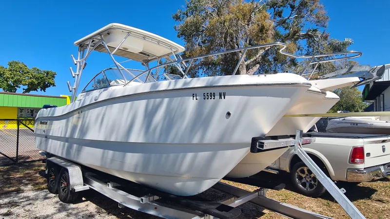 Slide: The Image of 2009 World Cat 250 DC boat on trailer, parked outdoors under clear blue sky. - 2
