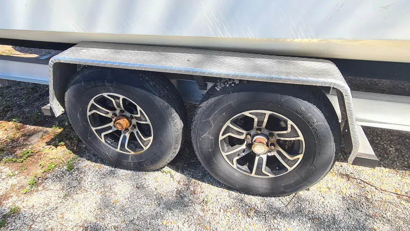 Slide: The Image of Trailer wheels of a 2009 World Cat 250 DC boat on gravel surface. - 27