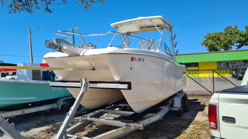 Slide: The Image of 2009 World Cat 250 DC boat on trailer, parked outdoors under clear blue sky. - 3