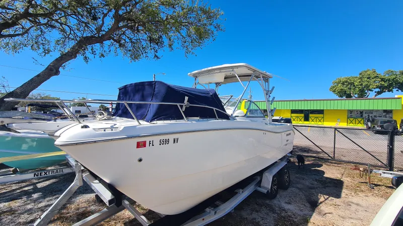 Slide: The Image of 2009 World Cat 250 DC boat on trailer, parked outdoors under clear blue sky. - 4